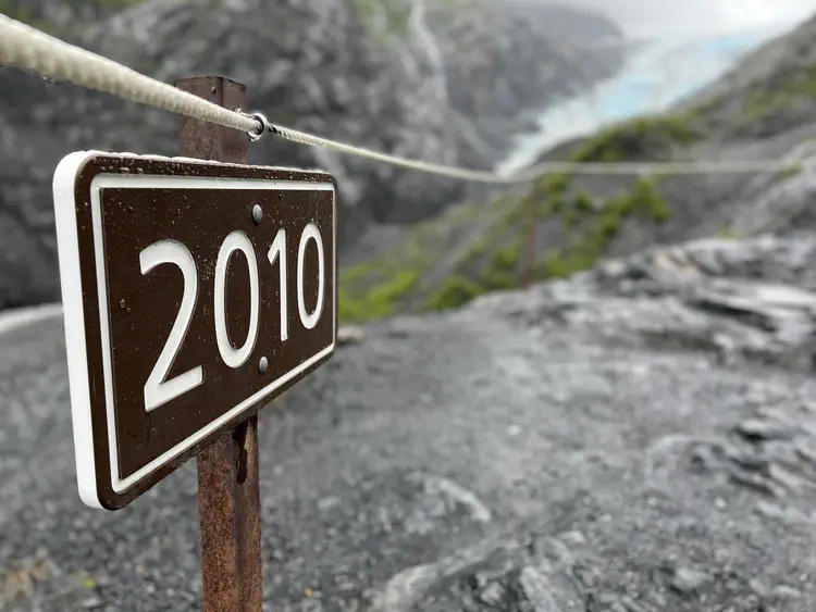 Glacial retreat. This sign marks the extent of the glacier in 2010. Looking at where the glacial extent in the background (in 2022) shows how much it has retreated in 12 years.